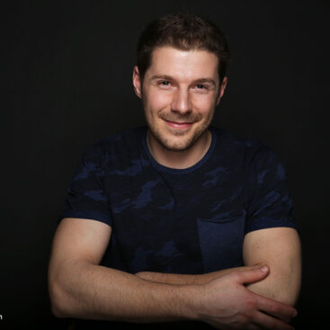 Gut aussehender glücklicher Mann, auf Stuhl sitzend fotografiert
